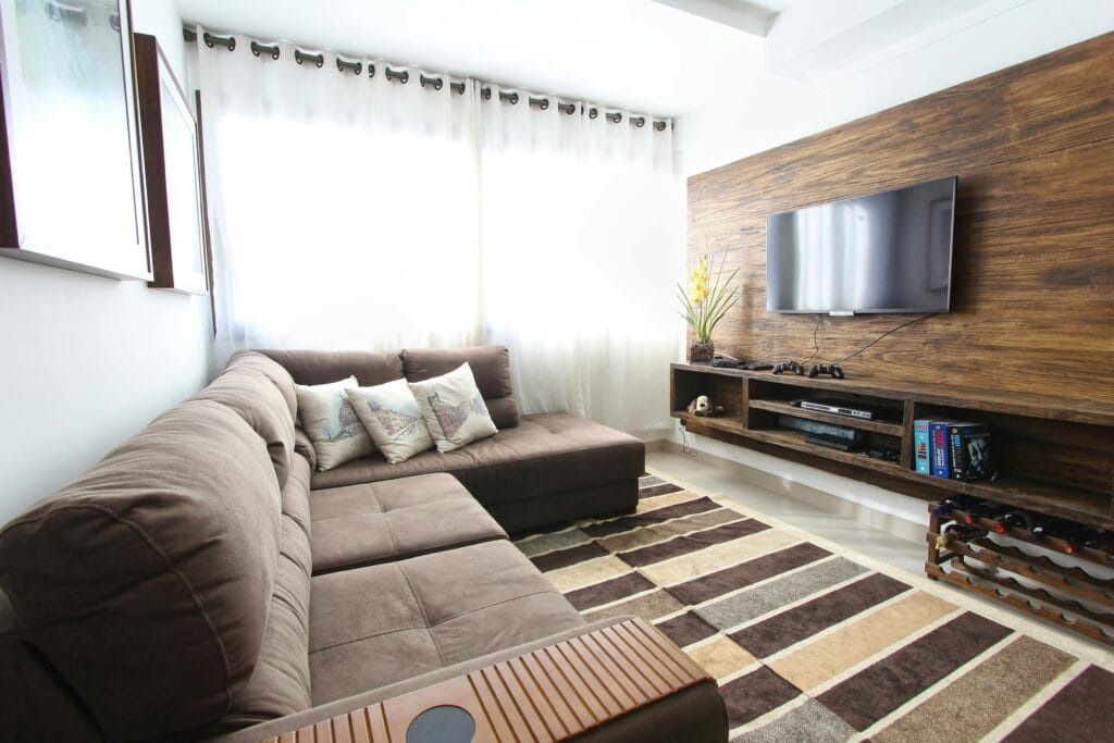 pexels-photo-275484-275484 Stylish modern living room featuring a brown sofa, wall-mounted TV, and interior decor.