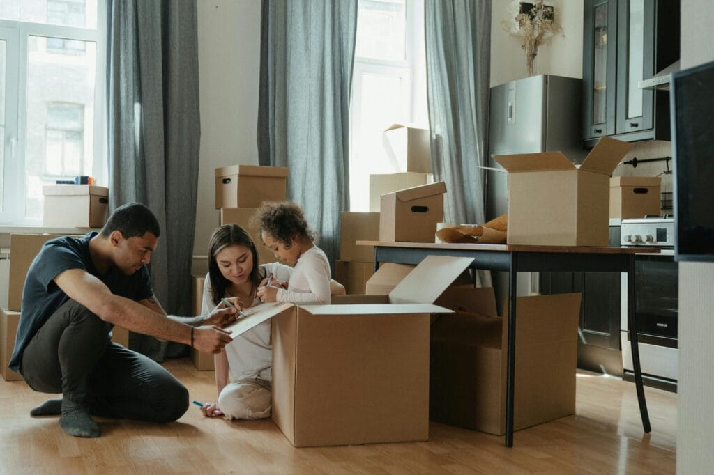pexels-photo-4569340-4569340 A family unpacks moving boxes in their new home kitchen, creating a cozy atmosphere.