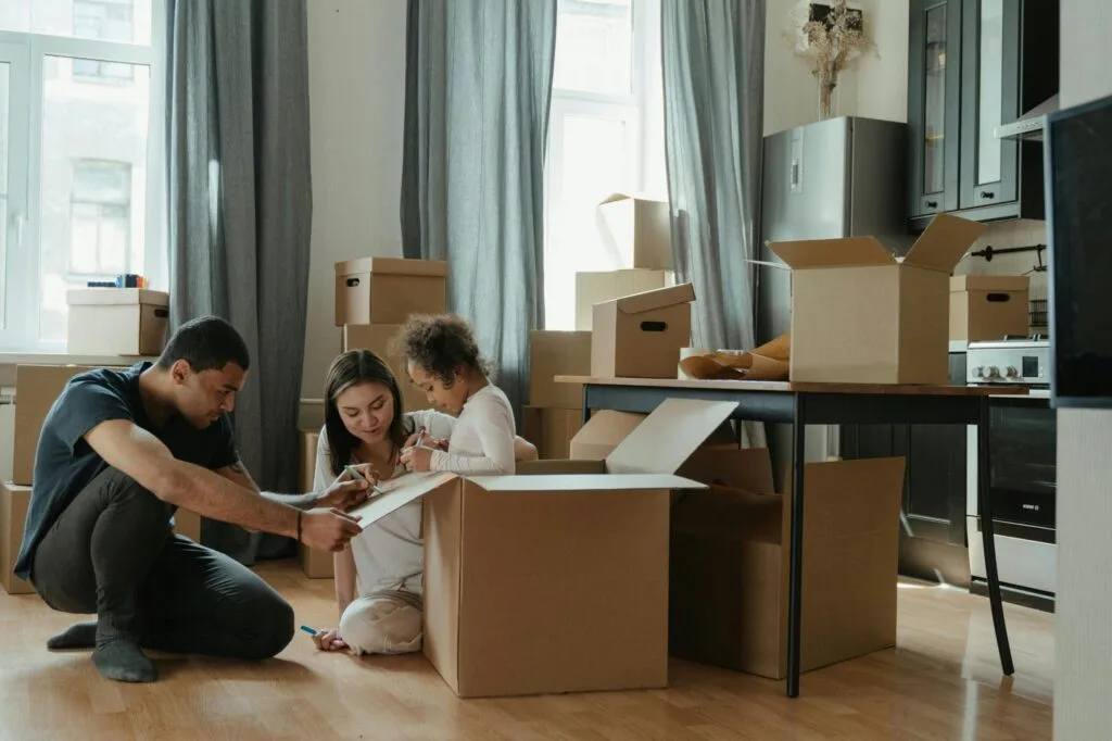 pexels-photo-4569340-4569340 A family unpacks moving boxes in their new home kitchen, creating a cozy atmosphere.